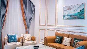 A modern living room with a sofa set, a coffee table, and a painting on the wall.