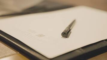Um tablet com um stylus sobre uma superfície plana, possivelmente uma mesa ou escrivaninha.