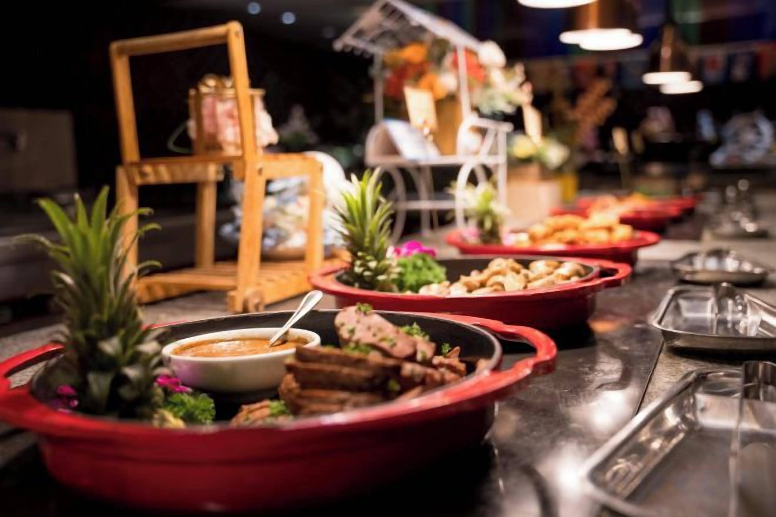 A buffet table with various dishes and a small plant.