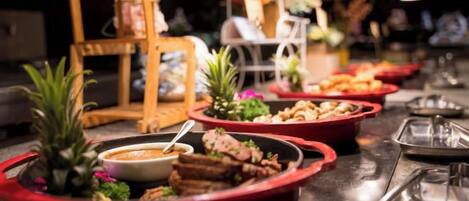 A buffet table with various dishes and a small plant.