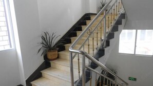 Eine Treppe mit schwarz-weißen Stufen, Metallgeländern und Blumentöpfen.