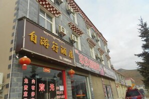 A building with a sign for a hotel and a restaurant. - Shangri-La Ziyouxing Hotel (Deqin)