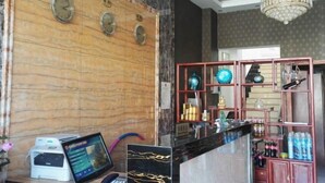 Ein Empfangsbereich mit Marmorwand, Uhren, einem Chandelier und einer Theke mit verschiedenen Artikeln.