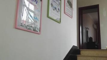Escada com corrimão e parede com pôsteres emoldurados.