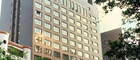 A multi-story building with a uniform facade, featuring a grid of windows and a flat roof.