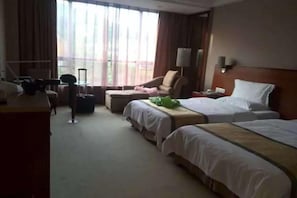 A hotel room with two beds, a desk, a chair, and a view of the outdoors. - Yuzhu Garden Hotel (Chongqing)