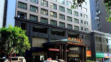 Un edificio de varios pisos con un letrero llamativo del Hotel Yuzhu Garden.
