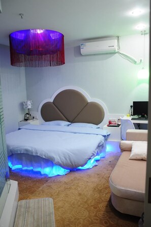 Una habitación de hotel con cama, escritorio, silla y lámpara.