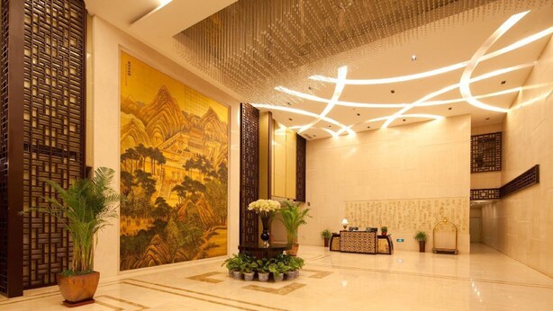 A spacious lobby with a traditional mural, modern lighting, and potted plants. - Wangfujing Xin Xiang Ya Yuan Apartment (Beijing)