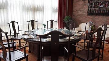 A round dining table with chairs, a glass top, and a central vase.
