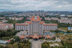 A large hotel with multiple buildings, surrounded by greenery and a parking area. - Maple Palace Hotel (Kunming)