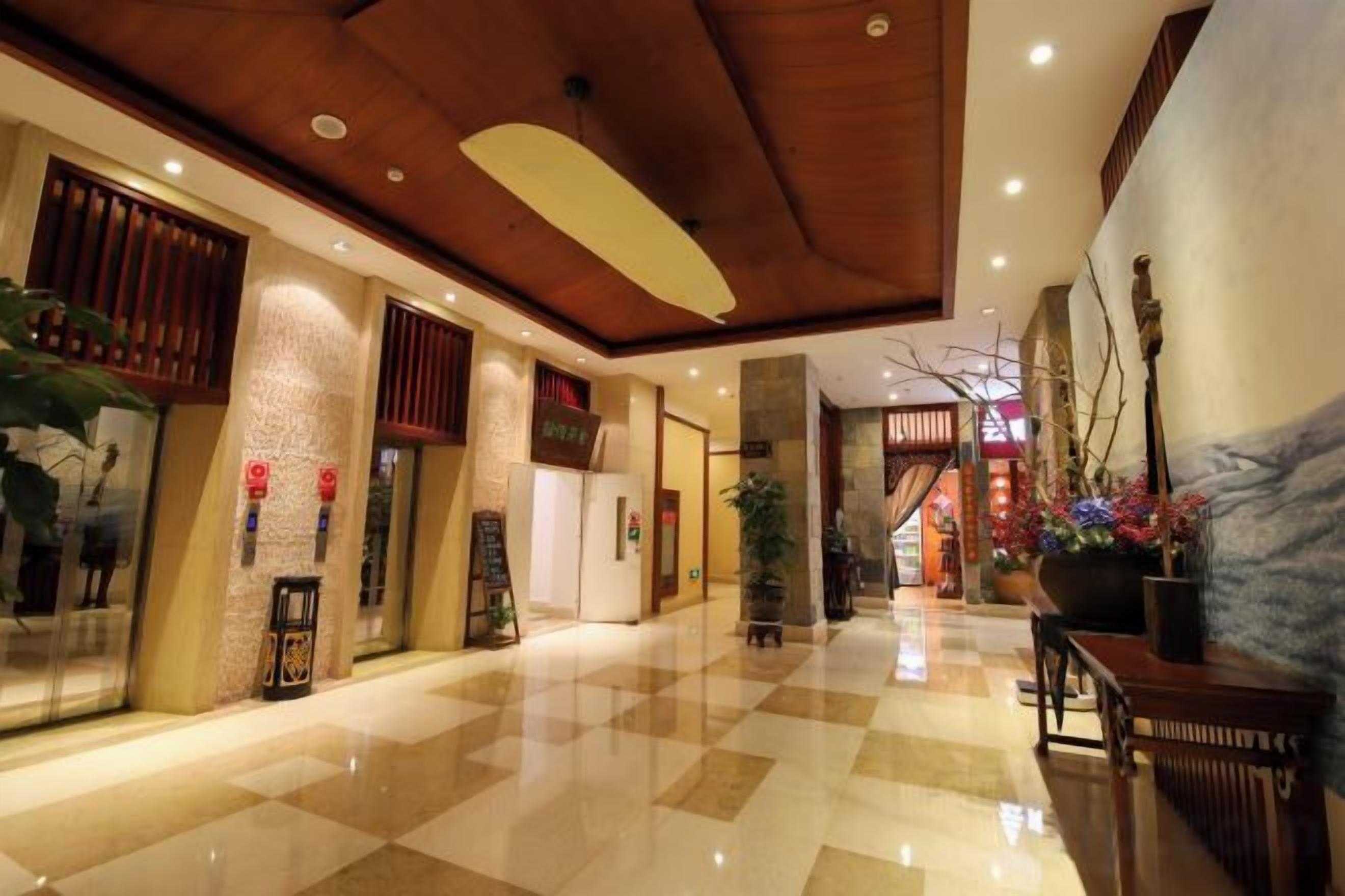 A hotel lobby with a checkered floor, wooden ceiling, and traditional decor.
