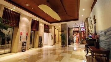 A hotel lobby with a checkered floor, wooden ceiling, and traditional decor.