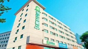 A multi-story hotel with a prominent green sign on the facade, multiple windows, and a flat roof. - Jinjiang Inn Style Taiyuan Exhibition Center (Taiyuan)