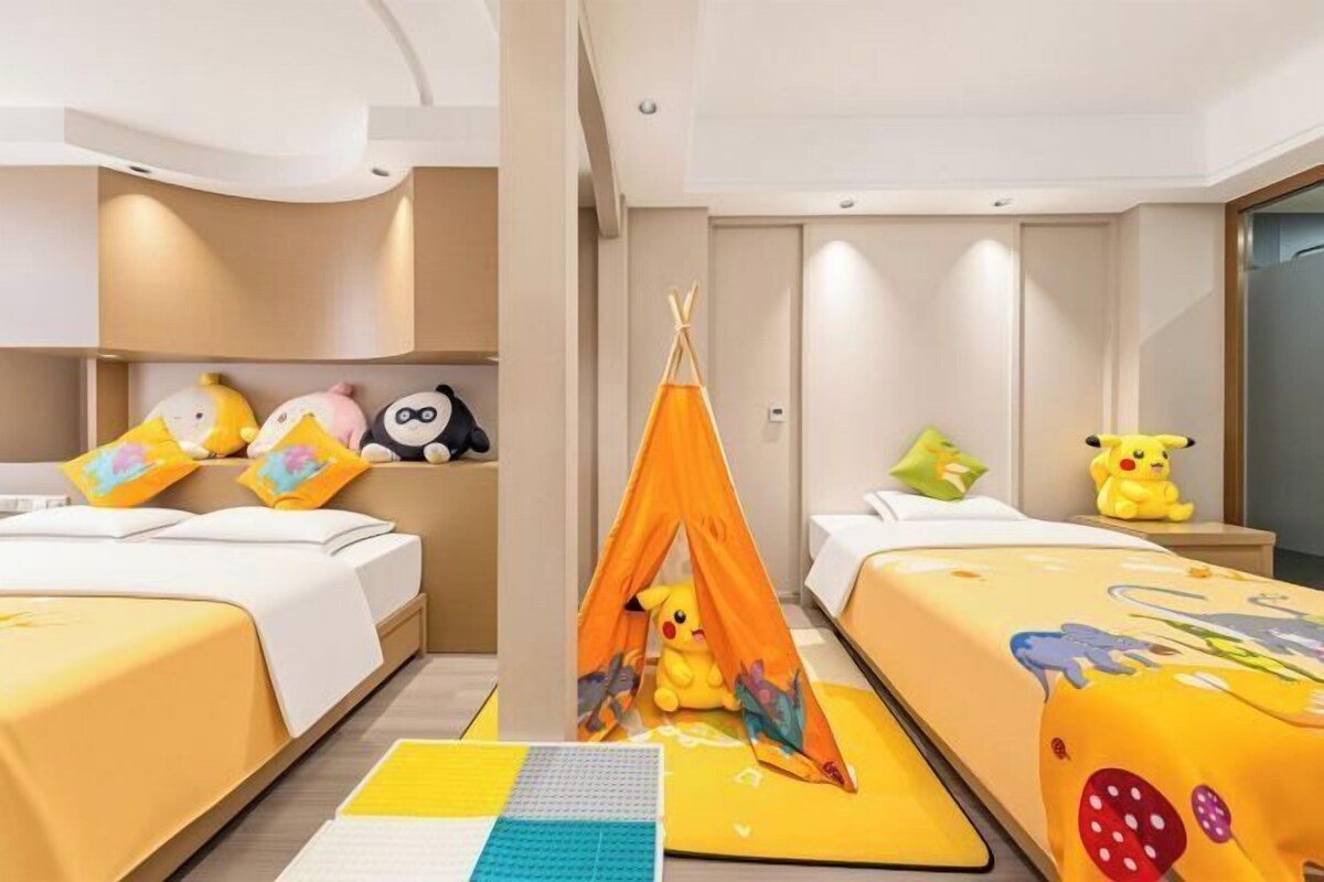 Une chambre d’hôtel avec deux lits, une tente et des peluches.