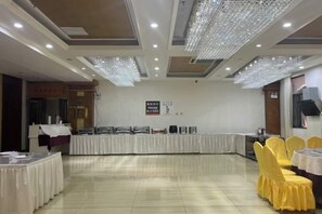 A banquet hall with a long table, yellow chairs, and a chandelier. - New Horizon Hotel (Luoping Sports Center, Qujing) (Qujing)