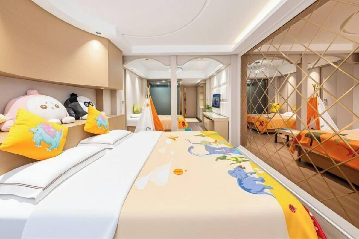 A hotel room with a bed, a desk, and a seating area with chairs.
