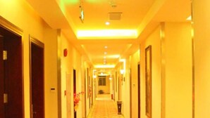 A hotel hallway with a carpeted floor, doors on both sides, and a long corridor leading to a distant end. - GreenTree Inn Guangzhou Chimelong Paradise Yuangang Metro Station Hotel (Guangzhou)