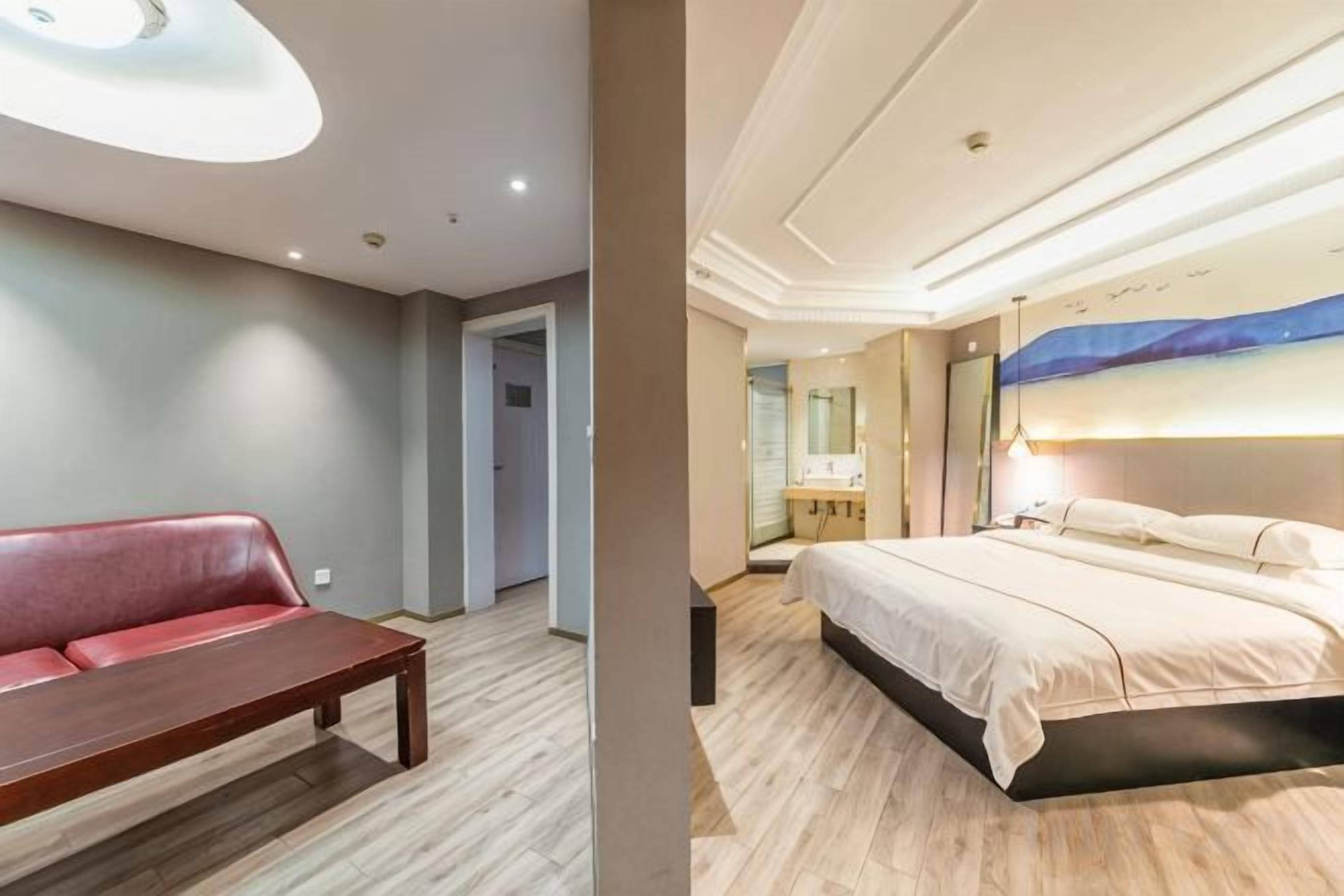 Una camera d'albergo con un letto, una panca e un quadro appeso al muro.