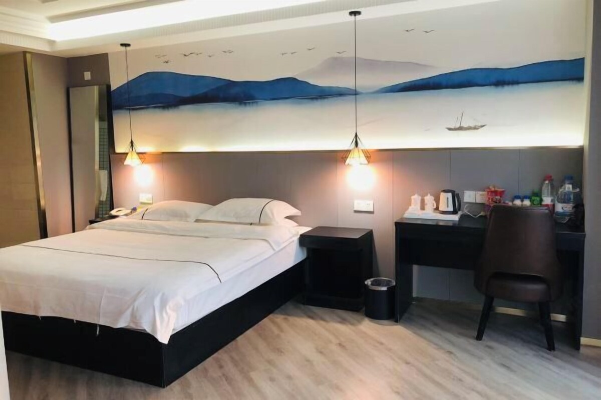 Ein modernes Hotelzimmer mit Bett, Schreibtisch und Stuhl.
