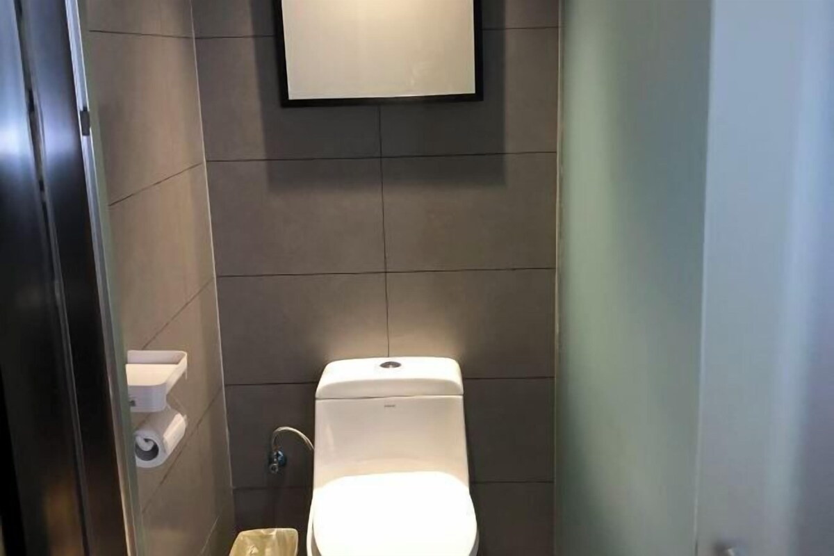 Ein kleines, modernes Badezimmer mit Toilette, Waschbecken und Spiegel.