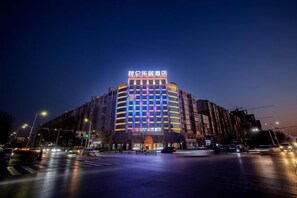 Un hotel de varios pisos con un letrero llamativo en la parte superior.
