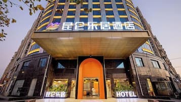 A hotel with a prominent entrance, a large sign, and a modern architectural design.