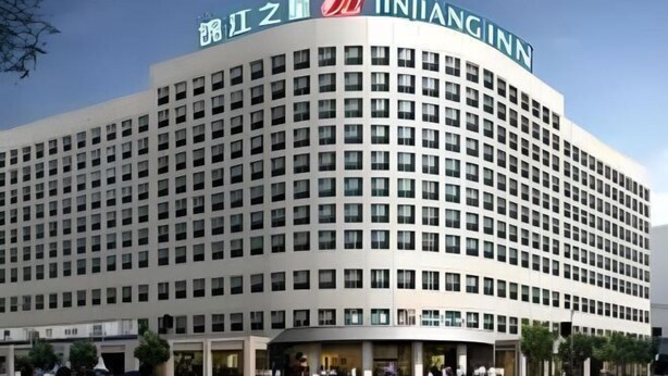 A multi-story hotel with a curved facade, featuring a prominent signage with Chinese characters and the name "INHIANGINN". - Jinjiang Inn Fuyang Yingshang Road (Fuyang)