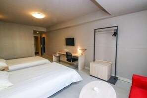 A hotel room with two beds, a desk, a chair, a TV, a wardrobe, and a red chair. - Jinjiang Inn Fuyang Yingshang Road (Fuyang)