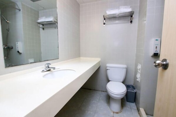 A bathroom with a white sink, a toilet, a mirror, and a towel rack. - Jinjiang Inn Fuyang Yingshang Road (Fuyang)