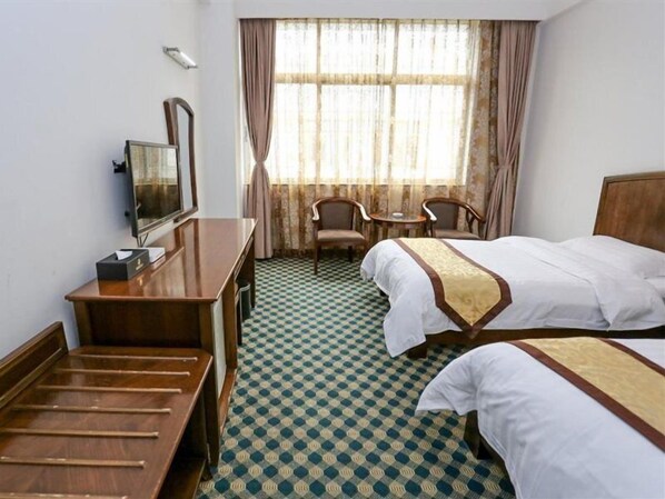 Una camera d'albergo con un letto, una scrivania, una sedia e una televisione.