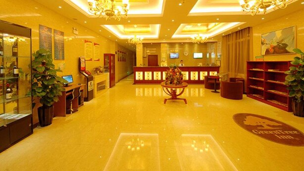 A hotel lobby with a reception desk, a chandelier, and a large plant. - Greentree Inn Jiangsu Taizhou Jingjiang Bus Statio (Taizhou)