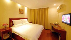 A hotel room with a bed, bedside table, chair, desk, and a TV. - Greentree Inn Jiangsu Taizhou Jingjiang Bus Statio (Taizhou)