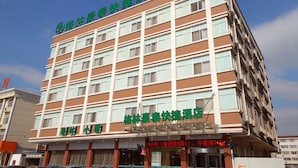 A multi-story hotel with a brown and white facade, multiple windows, and signage indicating amenities such as a conference room and a restaurant. - Greentree Inn Jiangsu Taizhou Jingjiang Bus Statio (Taizhou)