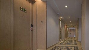 A hotel hallway with a carpeted floor, wooden doors, and a number sign indicating room 211. - Vienna Hotel Chaoyang Road - Nanning (Nanning)