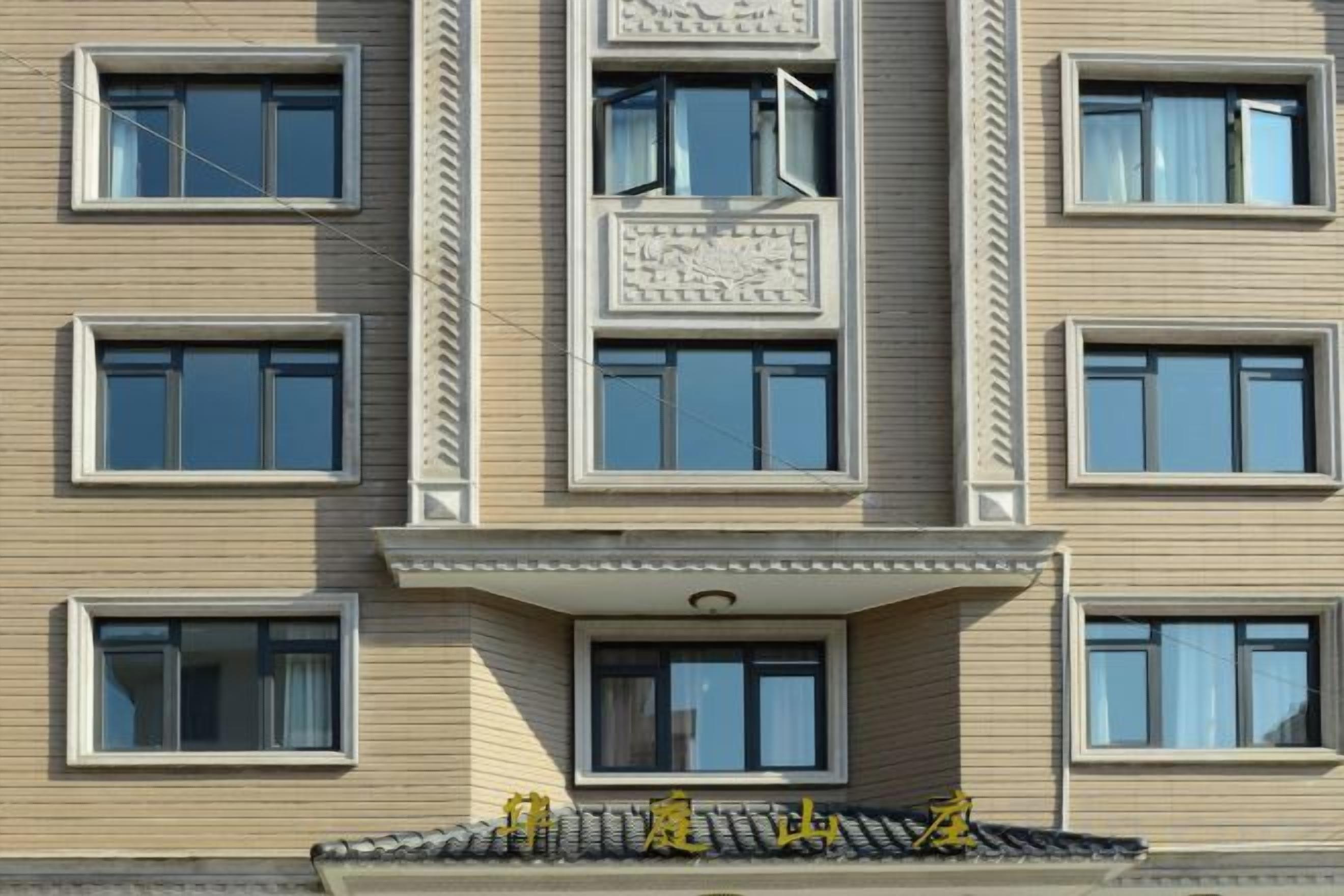 A multi-story building with a flat facade, rectangular windows, and a central entrance with a small balcony.