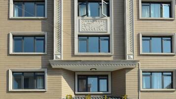 A multi-story building with a flat facade, rectangular windows, and a central entrance with a small balcony.