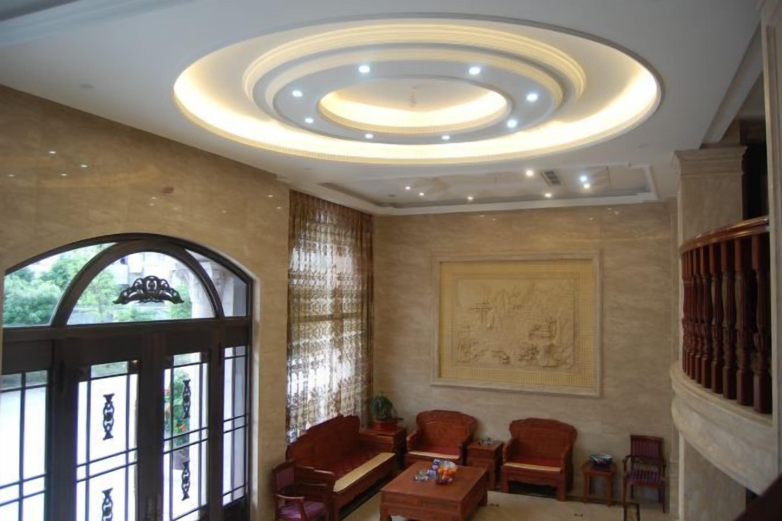 Una stanza dal design tradizionale, con una porta in legno, un grande quadro appeso al muro e un'area salotto con diverse sedie e un tavolo.