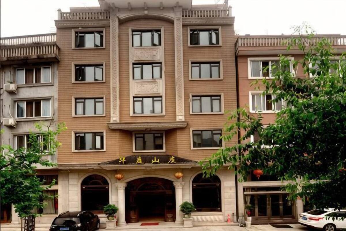 Ein mehrgeschossiges Hotel mit zentralem Eingang, zahlreichen Fenstern und einer Schilder über dem Eingang.
