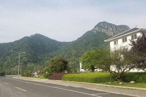 A residential street with a house, a mountain, and a clear sky. - Yandang Huating Villa (Wenzhou)