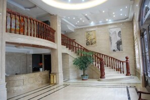 A grand lobby with a marble floor, a staircase with wooden railings, and a large potted plant. - Yandang Huating Villa (Wenzhou)