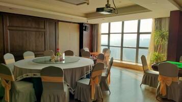 A conference room with a round table, chairs, and a projector.