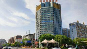 A multi-story hotel with a modern design, located in an urban setting with other buildings nearby.