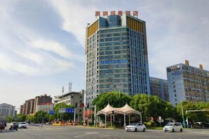 A multi-story hotel with a modern design, located in an urban setting with other buildings nearby. - Jiaqi Landscape Hotel (Chizhou)