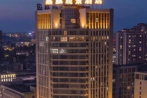 A high-rise building with illuminated signage at the top.