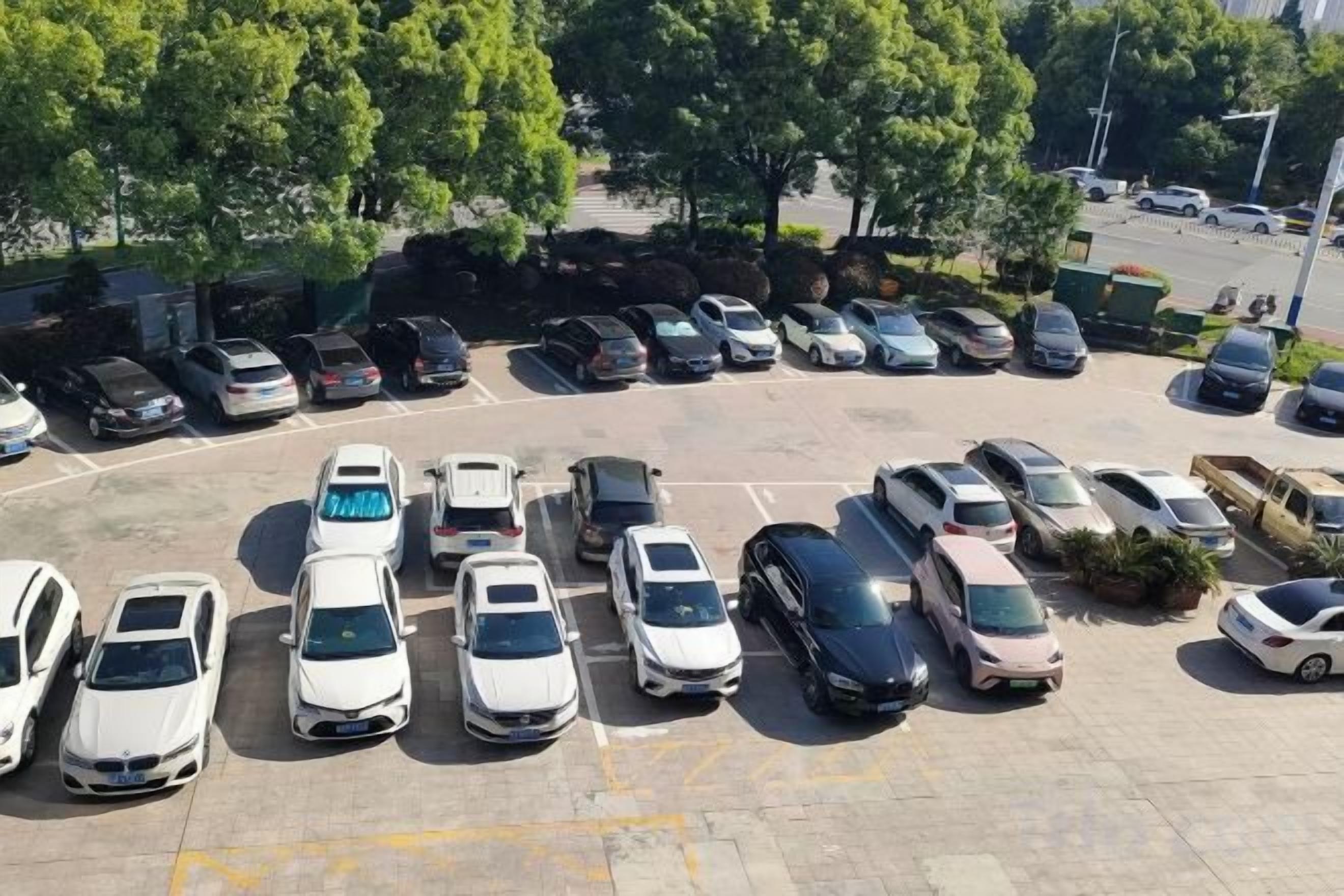 Un estacionamiento con varias filas de coches aparcados.