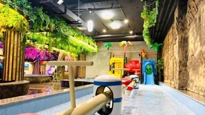 An indoor play area with a pool, slides, and climbing structures. - Royal Hot Spring Hotel (Baishan)