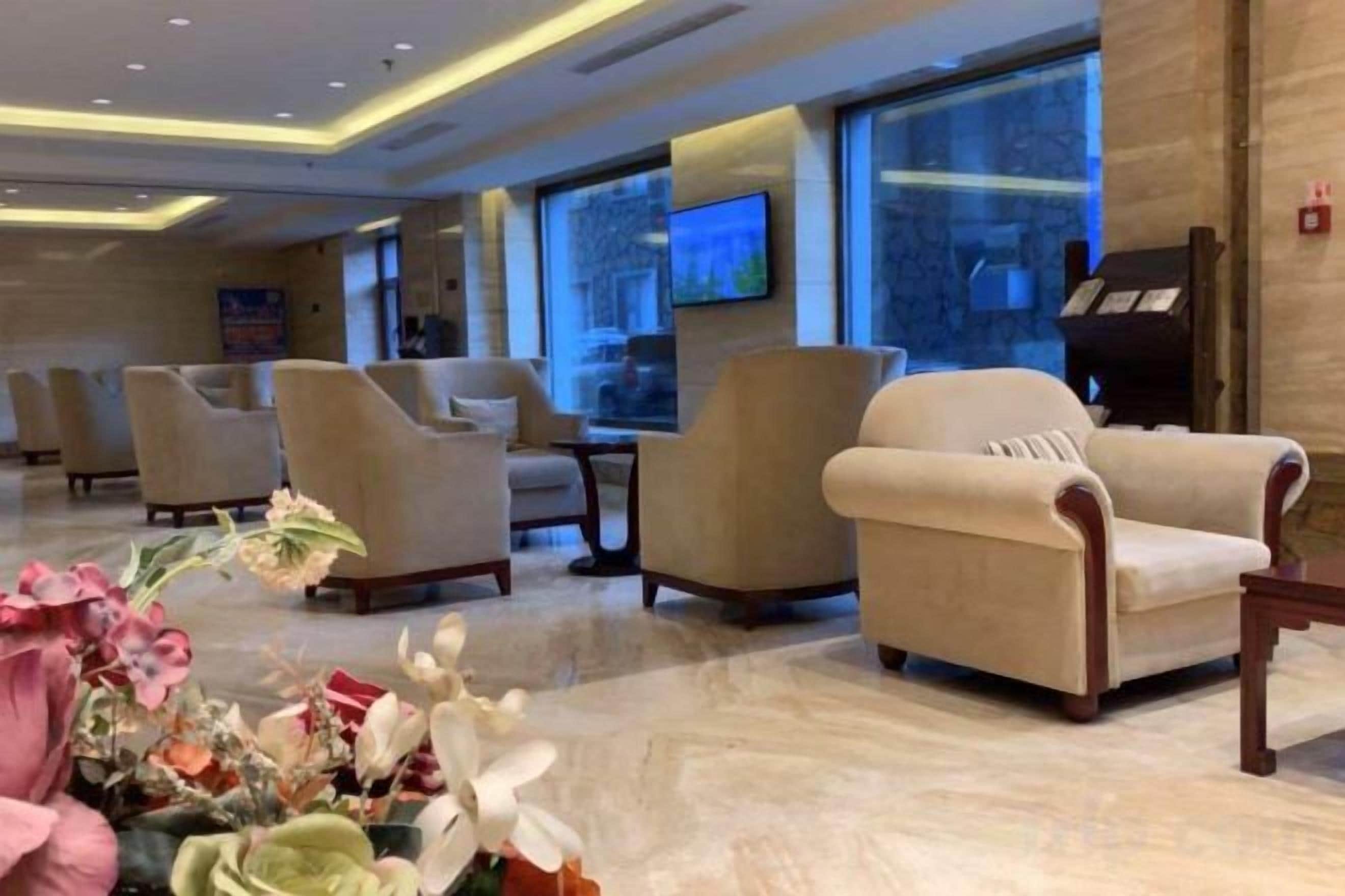 Een hotel lobby met zithoek, een televisie en een open haard.