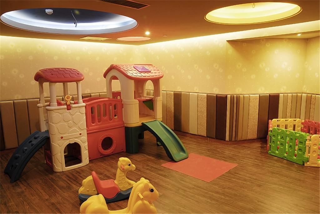 A children's play area with a slide, climbing structures, and soft play toys.