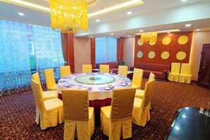 A conference room with a round table, yellow chairs, and a glass centerpiece. - Longshan Hotel (Handan)